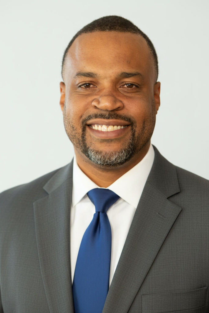 Justin C. Stewart in a gray suit and blue tie
